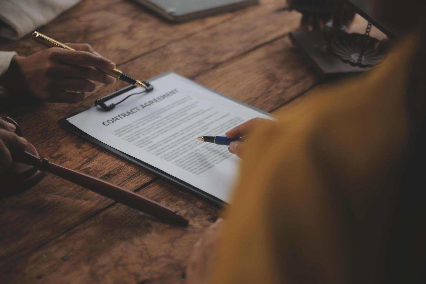 Business and lawyers discussing contract papers with brass scale on desk in office. Law, legal services, advice, justice and law concept picture with film grain effect photo
