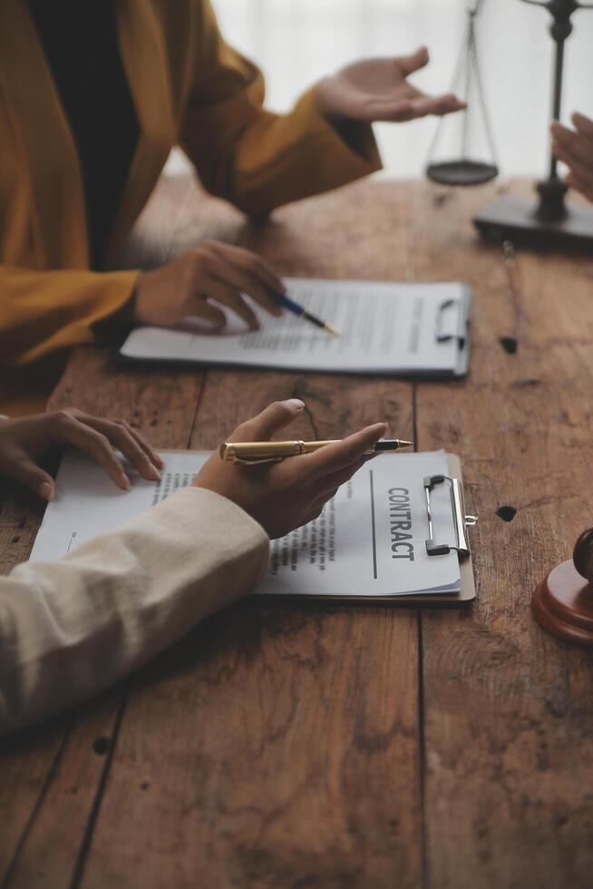 Business and lawyers discussing contract papers with brass scale on desk in office. Law, legal services, advice, justice and law concept picture with film grain effect photo