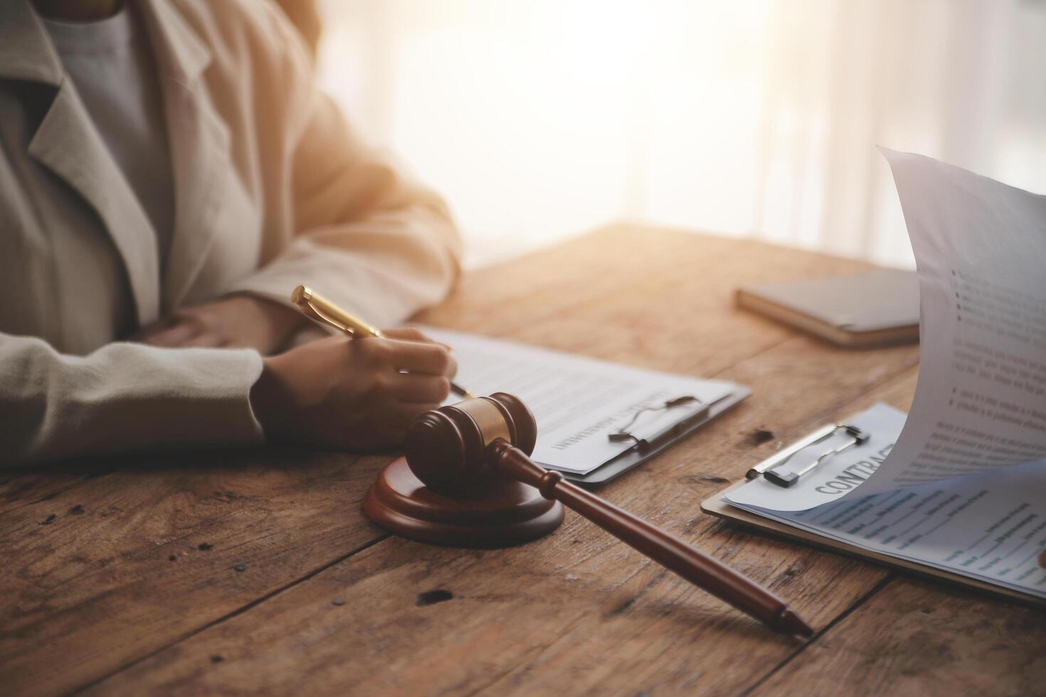 Business and lawyers discussing contract papers with brass scale on desk in office. Law, legal services, advice, justice and law concept picture with film grain effect photo