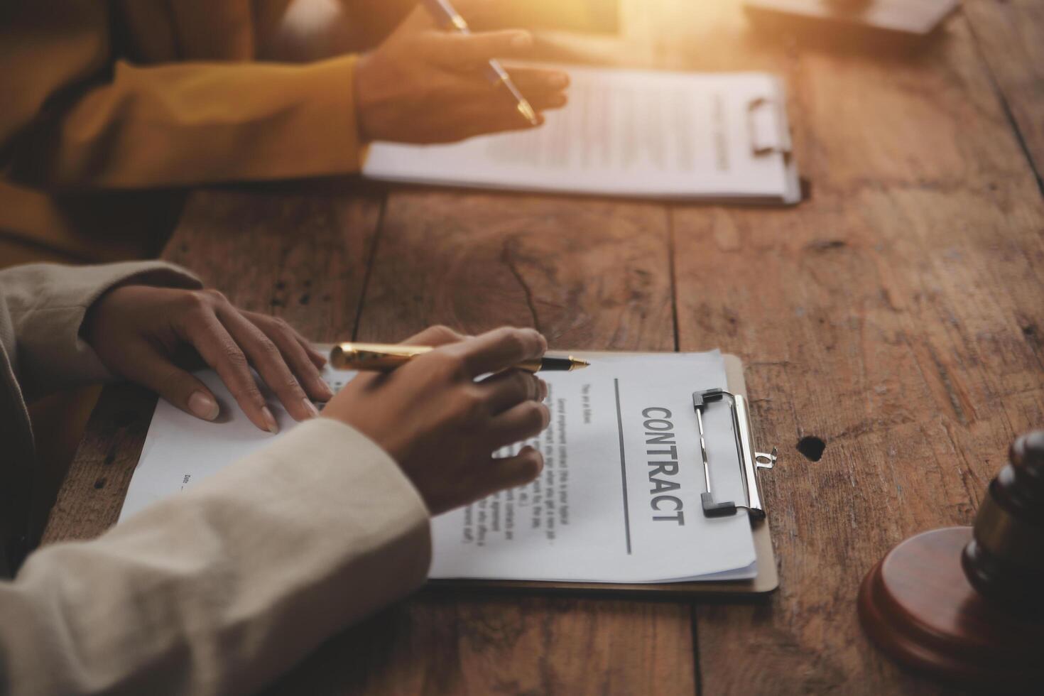 Business and lawyers discussing contract papers with brass scale on desk in office. Law, legal services, advice, justice and law concept picture with film grain effect photo