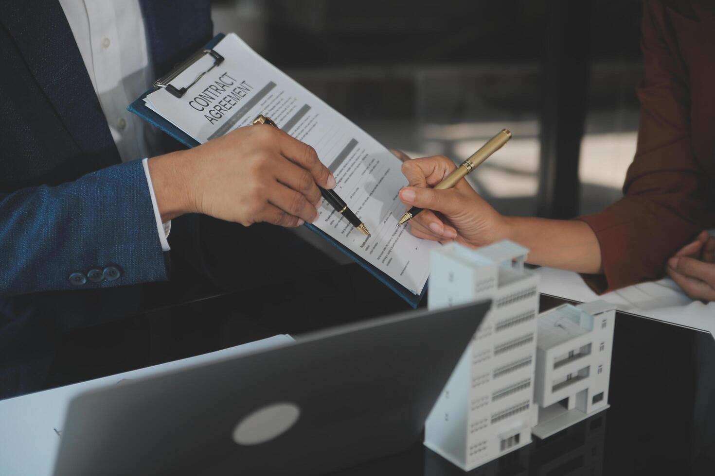 Real estate agent and customer signing contract to buy house, insurance or loan real estate.rent a house,get insurance or loan real estate or property. photo