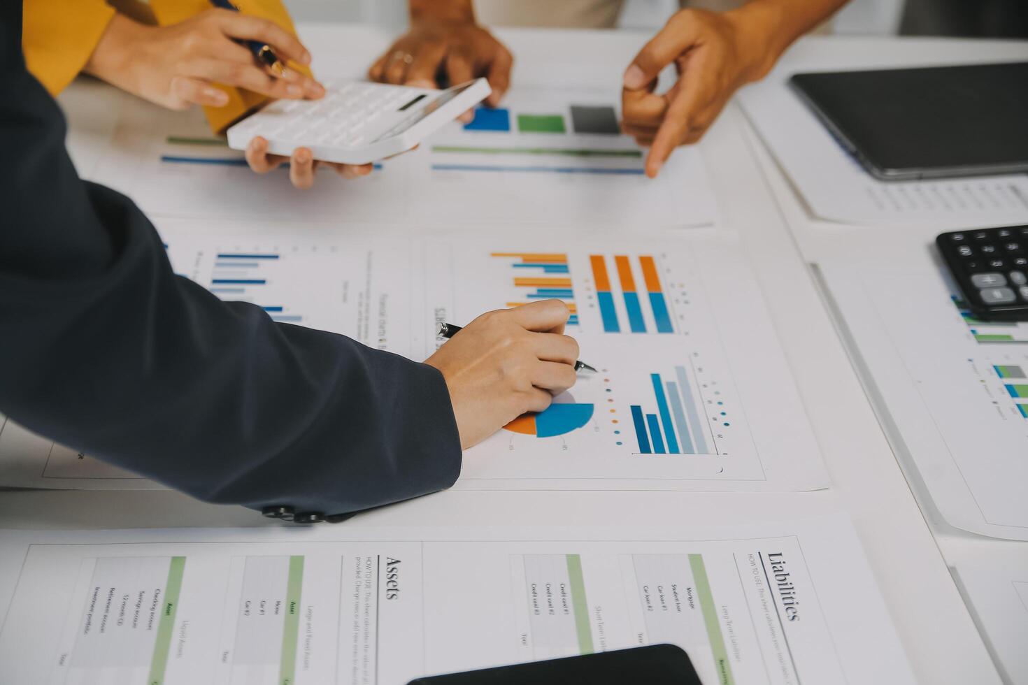 Financial analysts analyze business financial reports on a digital tablet planning investment project during a discussion at a meeting of corporate showing the results of their successful teamwork. photo
