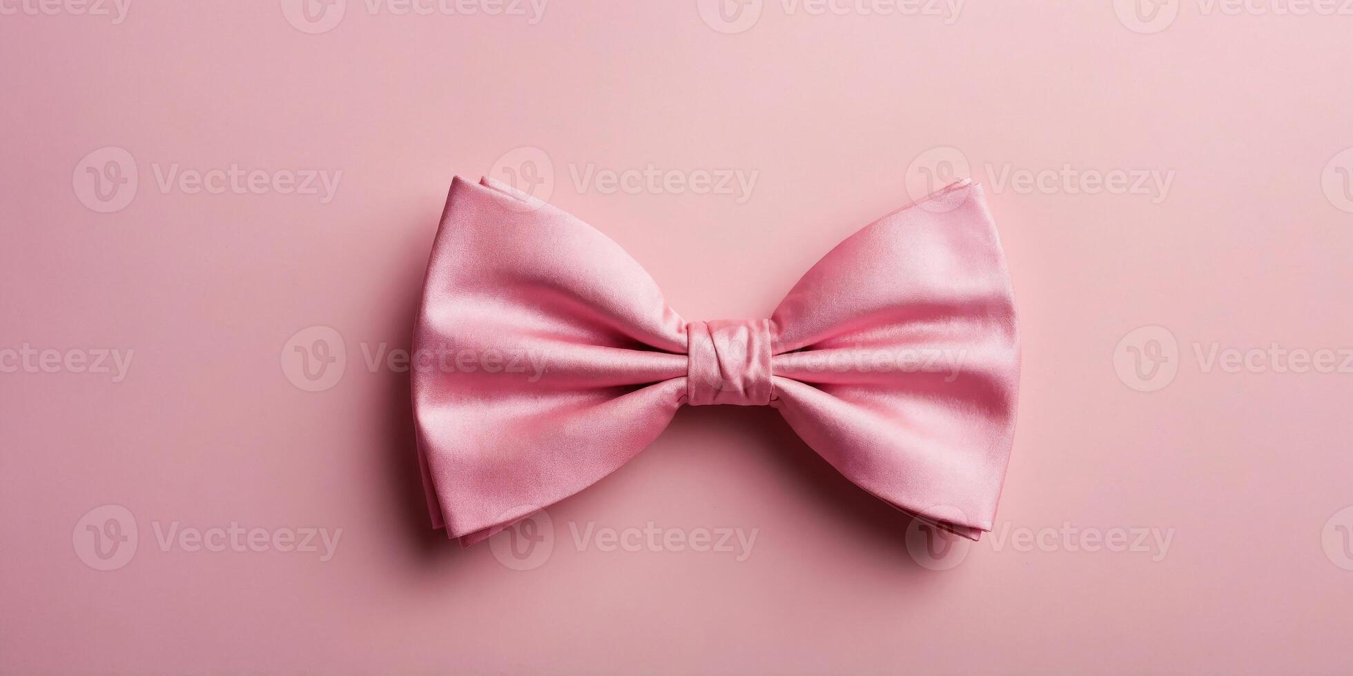 Top view of pink bow tie on pink background. photo