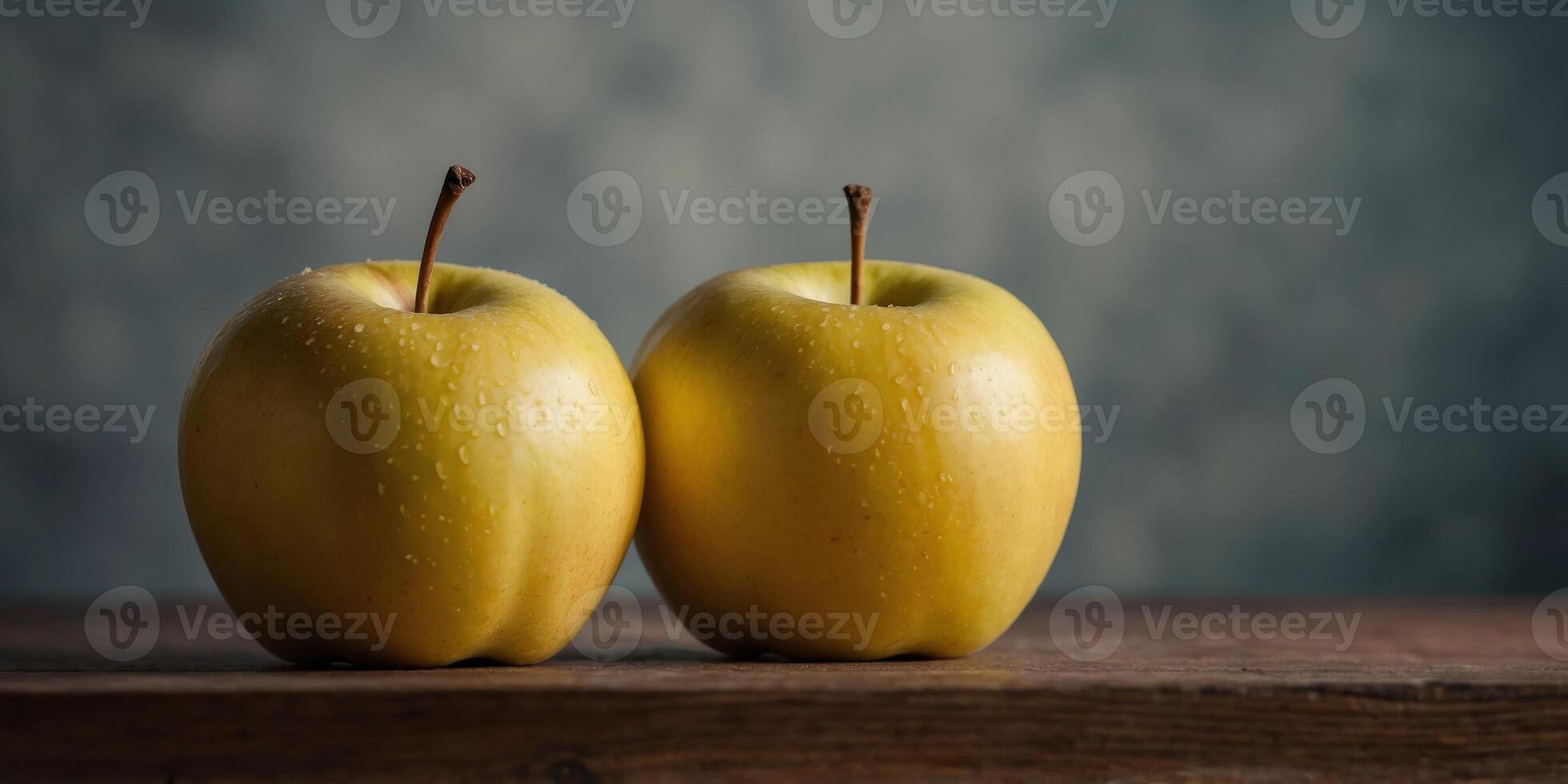Three yellow apples are lined up on a table. photo