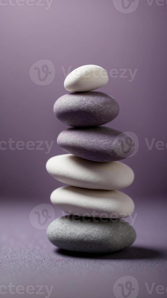 Stack of smooth white stones on a purple background. photo