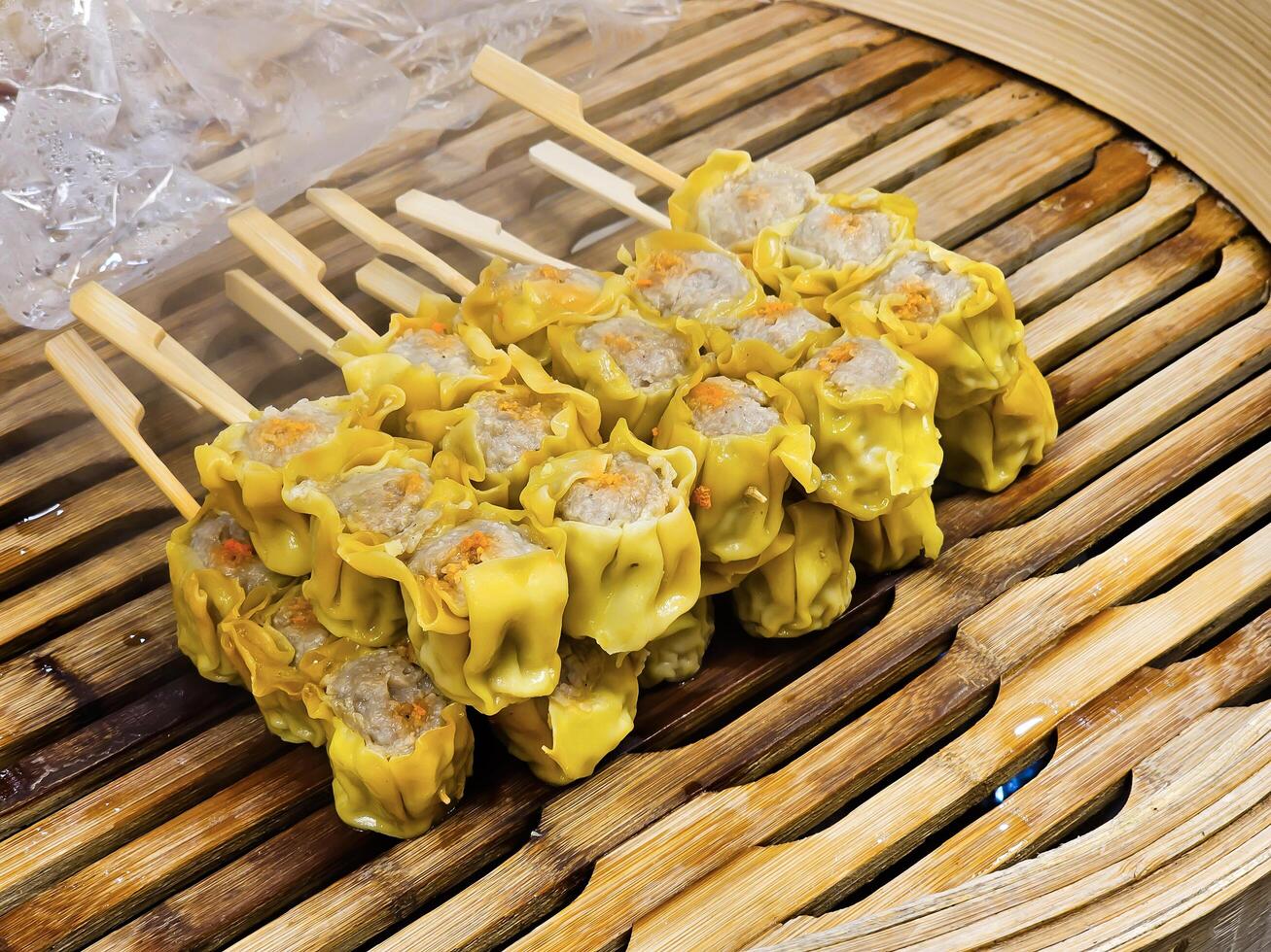 Steamed dumplings with pork and shrimp on skewers, steamed on a bamboo steamer photo