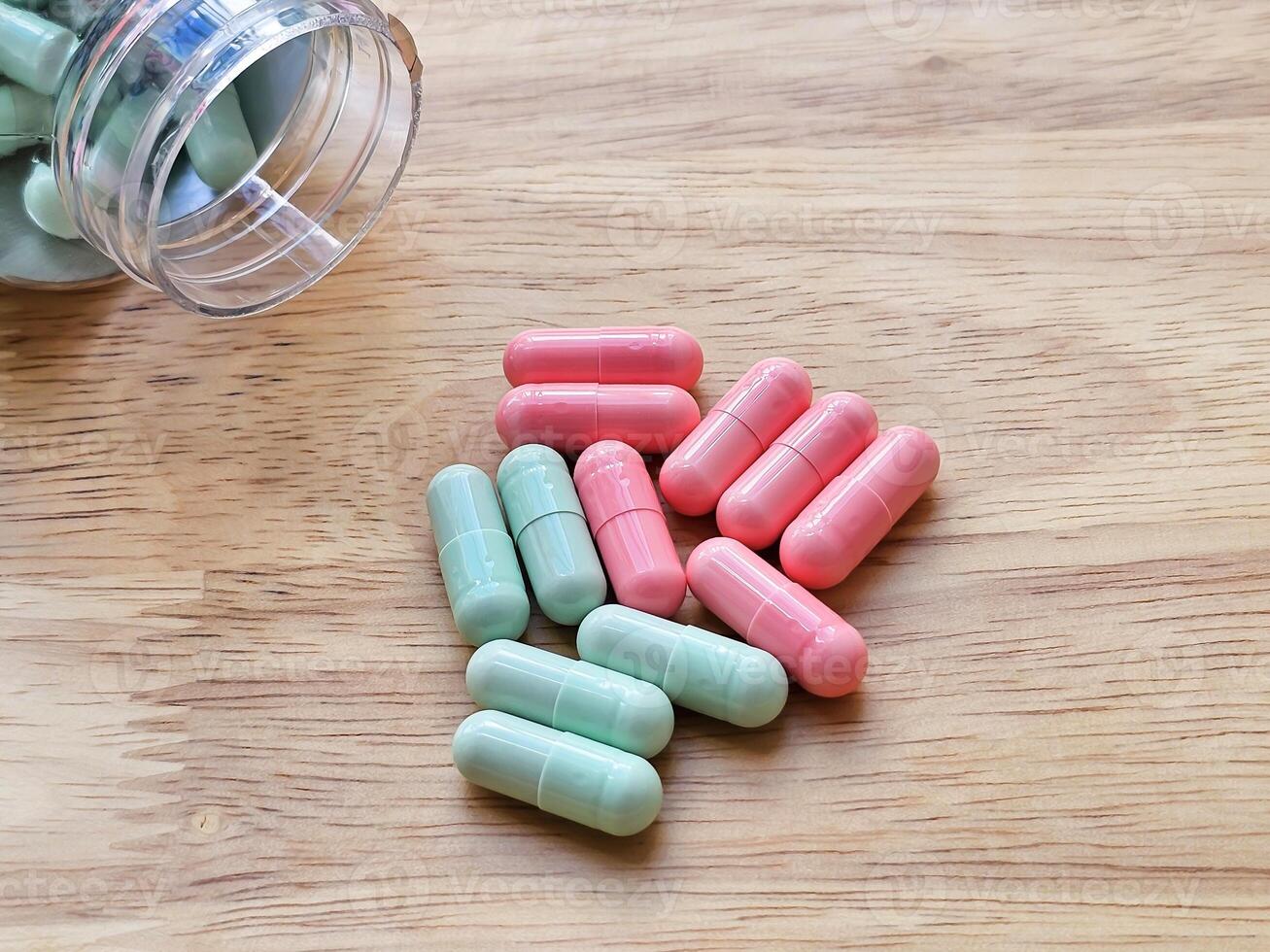 Pill box and vitamins on a wooden board represent a health care concept and food supplement. photo
