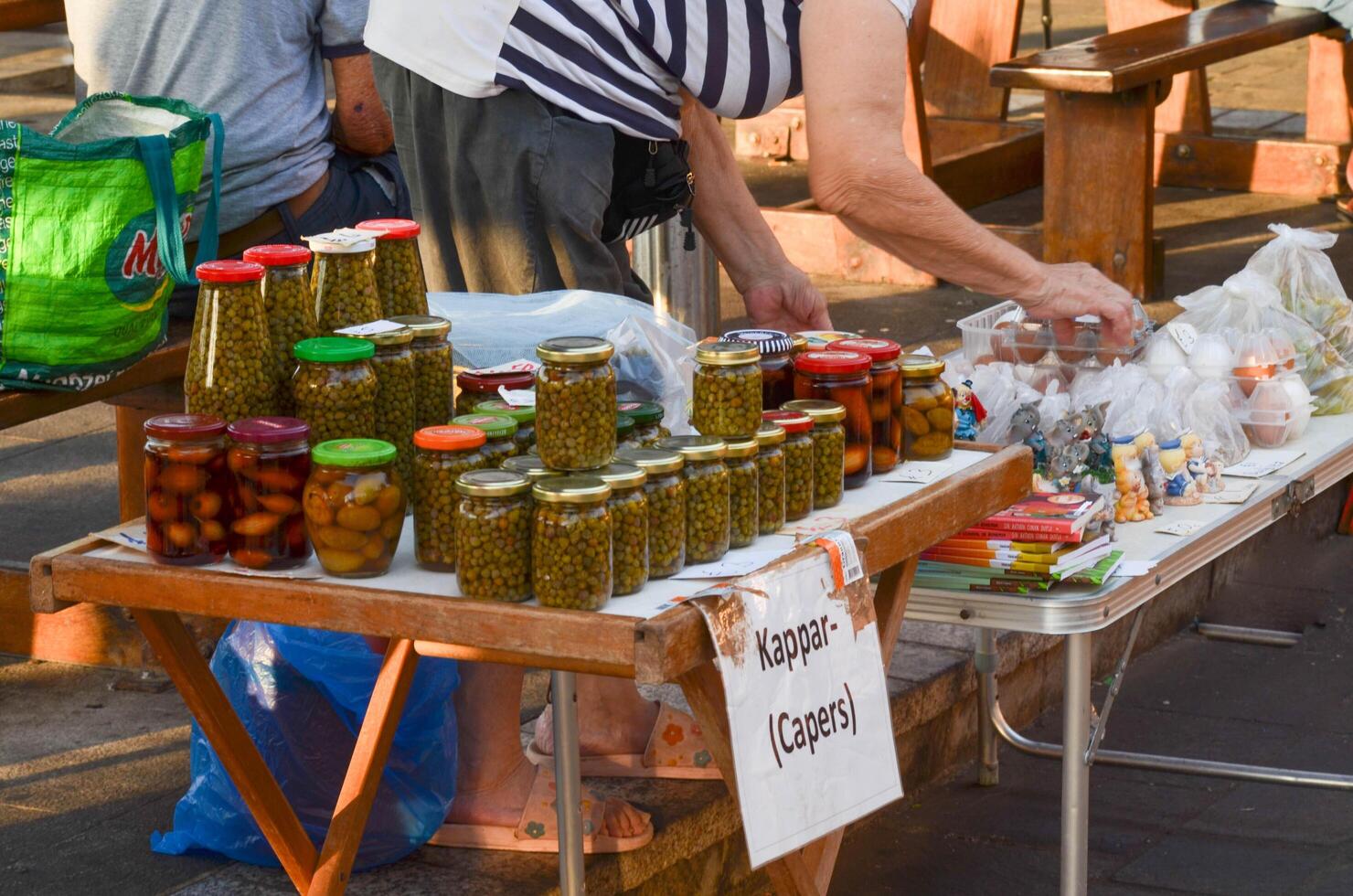 Elderly Woman Selling Homemade Goods at Fishing Market. A heartwarming image of an elderly woman selling her homemade products at a bustling local fishing market. photo