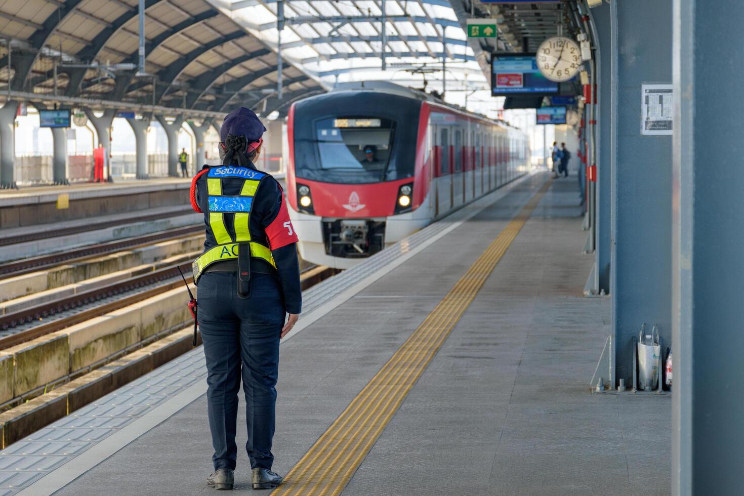 Bangkok, Thailand - October 13, 2024, Station security officers woman are on duty at commuter train of the state railway of Thailand SRT, Red Line Electric Train is a public transport system. photo