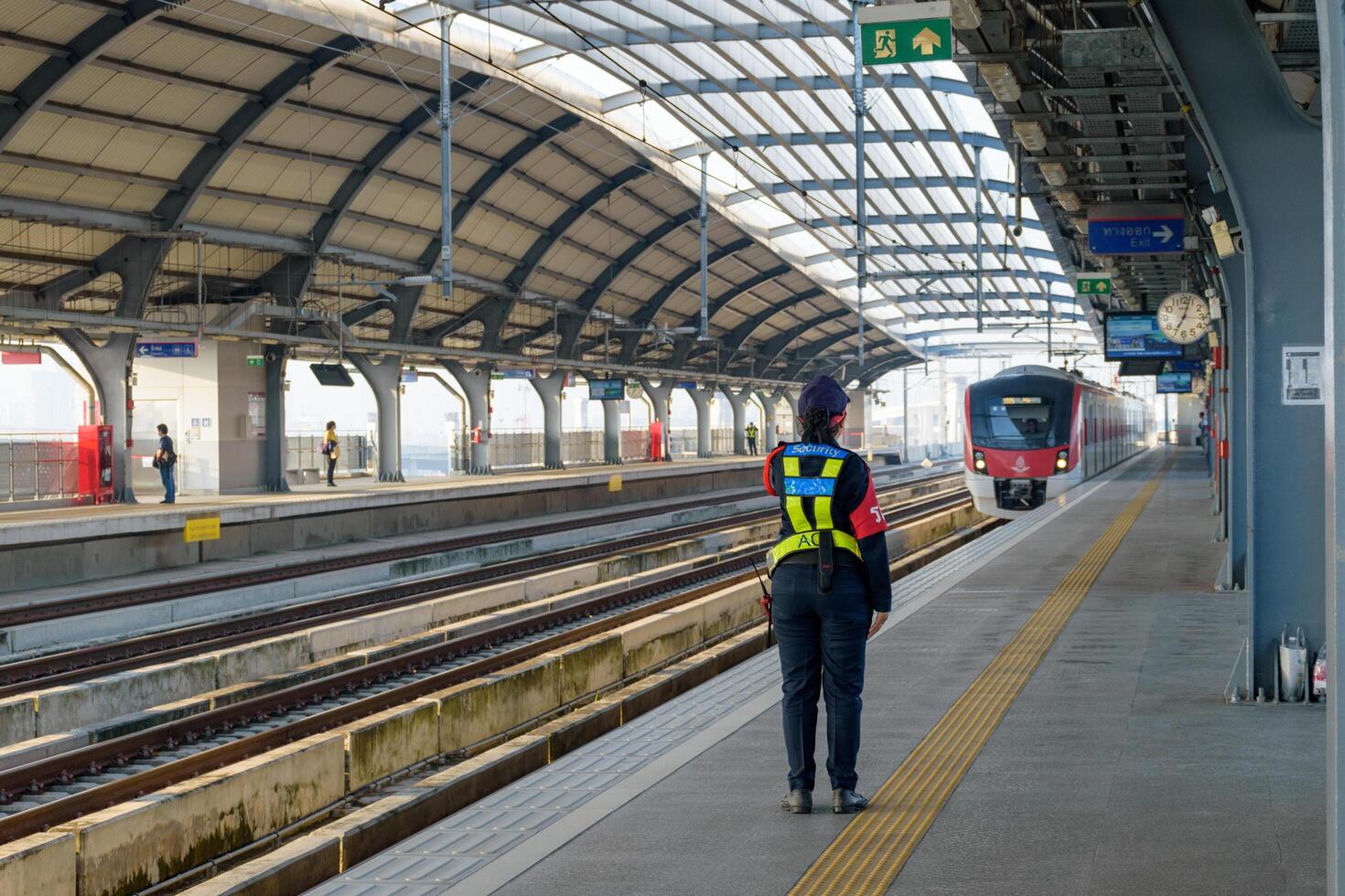 Bangkok, Thailand - October 13, 2024, Station security officers woman are on duty at commuter train of the state railway of Thailand SRT, Red Line Electric Train is a public transport system. photo