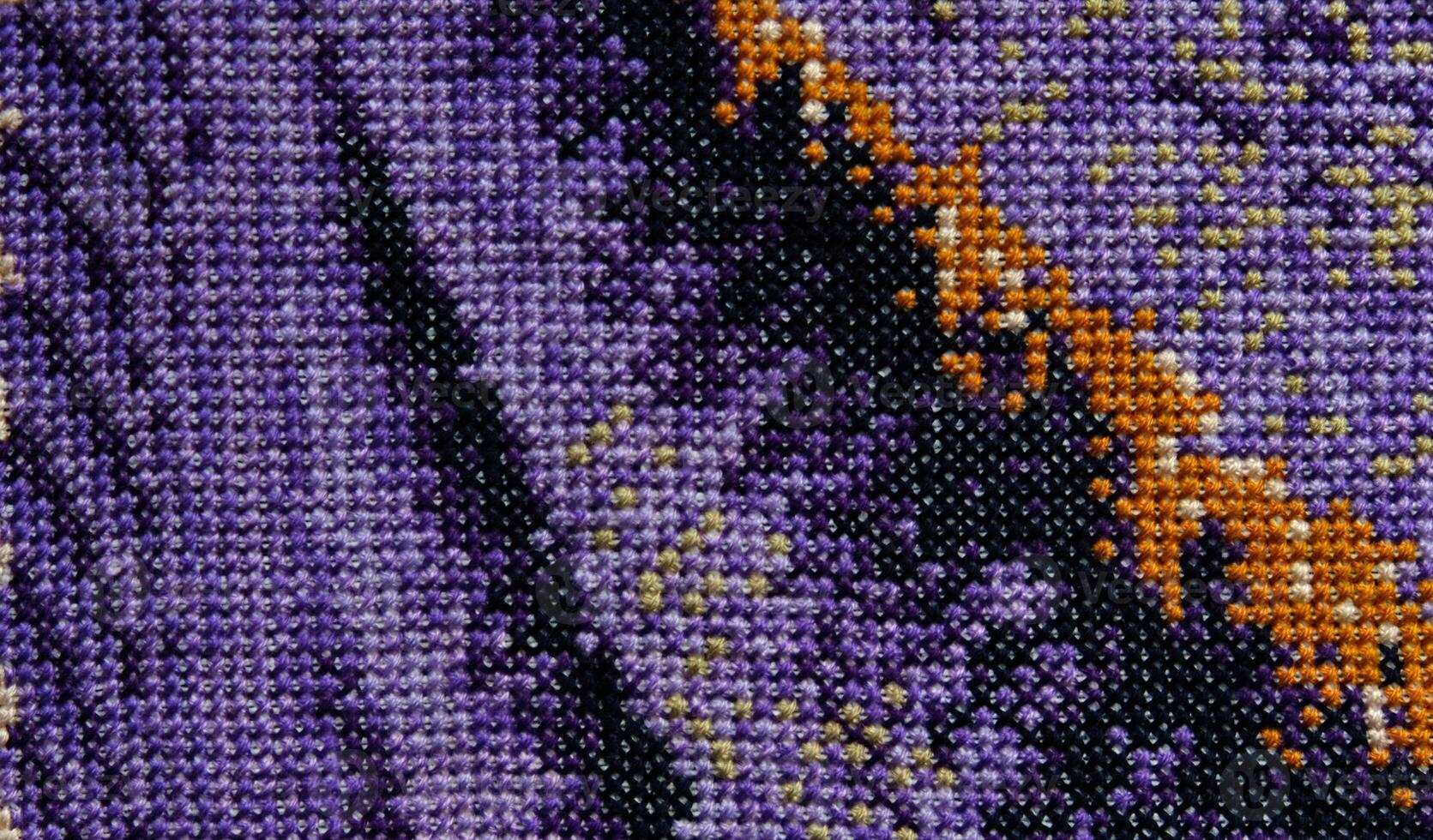 Purple, violet and brown close-up cross stitch background. Abstract Embroidered handmade Pattern. Needlework and DIY concept. Top view, macro, flat lay, mockup. photo