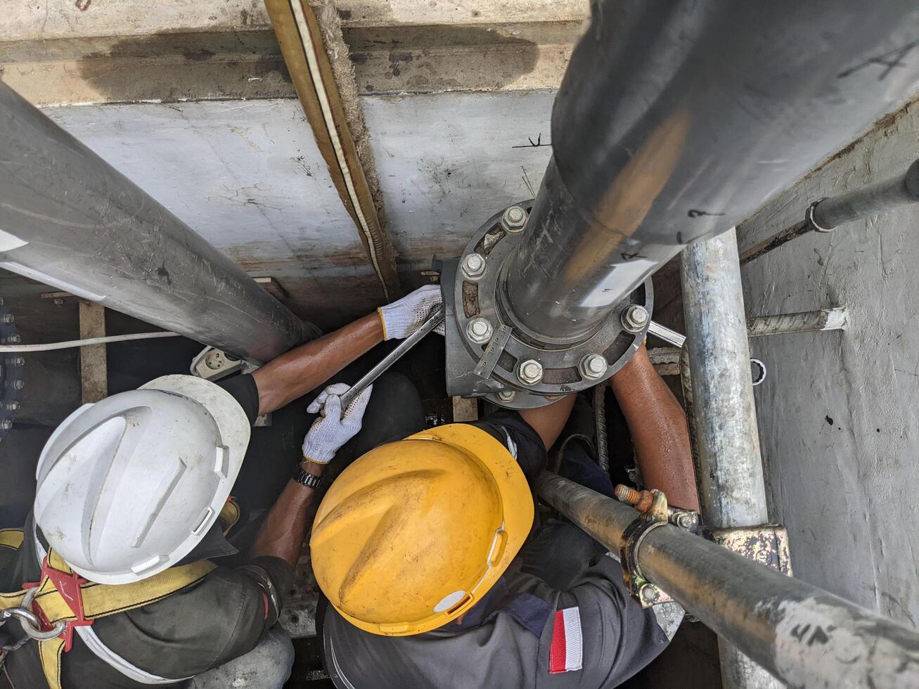Two Workers Repairing a Large Pipe in a Pit photo