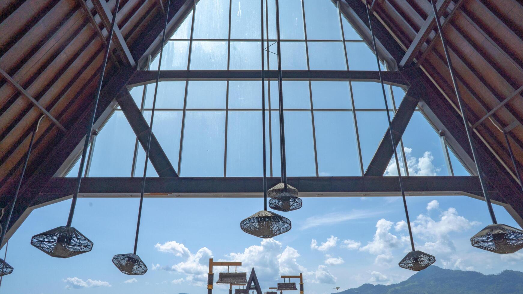 Modern Architectural Design with Skylights and Hanging Lamps. A view of a modern building's interior with large skylights and hanging lamps, showcasing the design's emphasis on natural light. photo