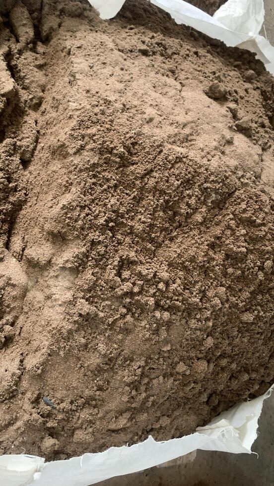 Bottom ash from the waste recycling factory in a Bag. Close-up image of a bag filled with brown sand, showing its granular texture and earthy tones. photo