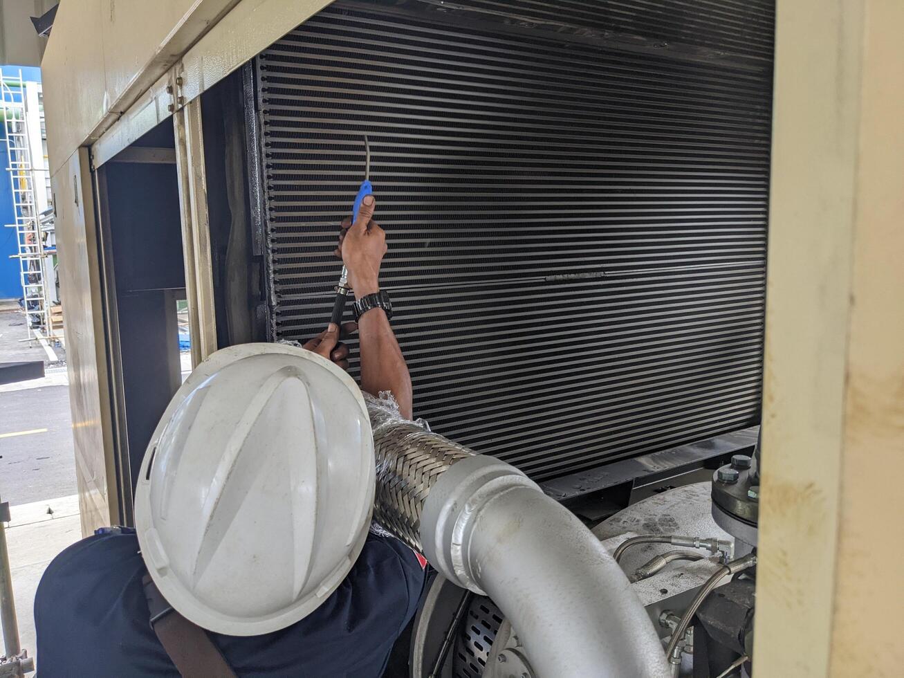 Technician Inspecting and cleaning radiator air compressor. photo