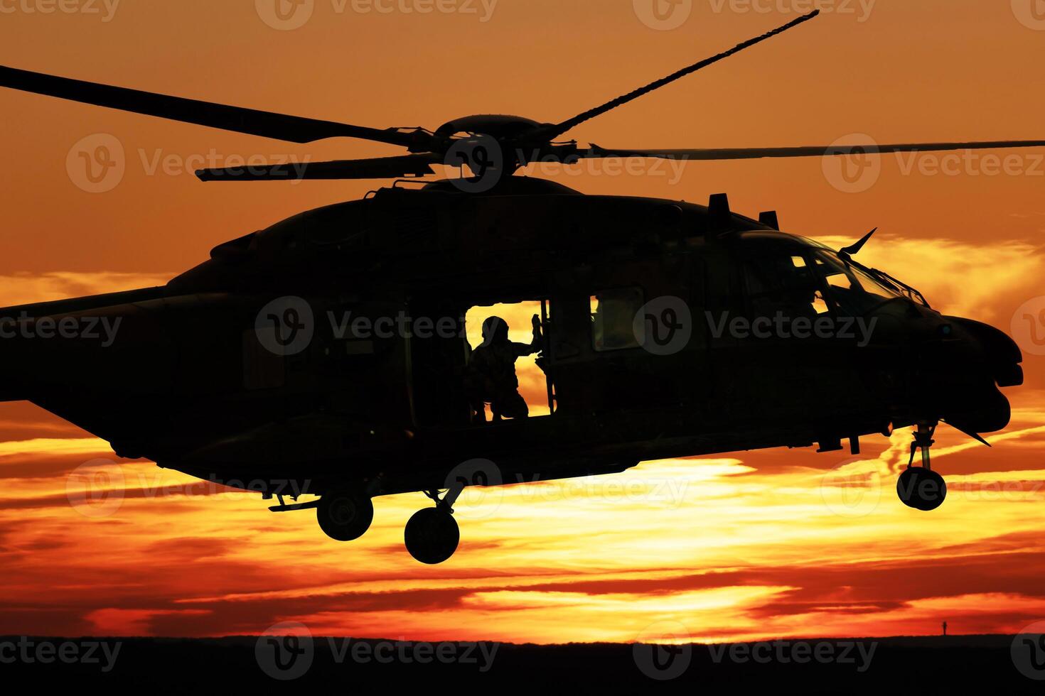 Silhouette of a combat helicopter at sunset in the sky, side view, air transportation photo