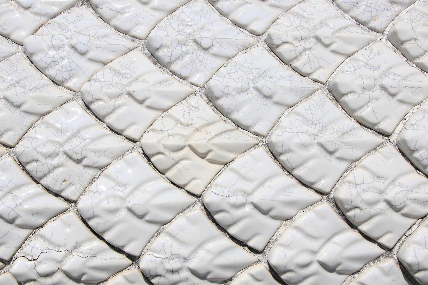 Luxurious pearl white fish scale pattern tiles on cement wall photo