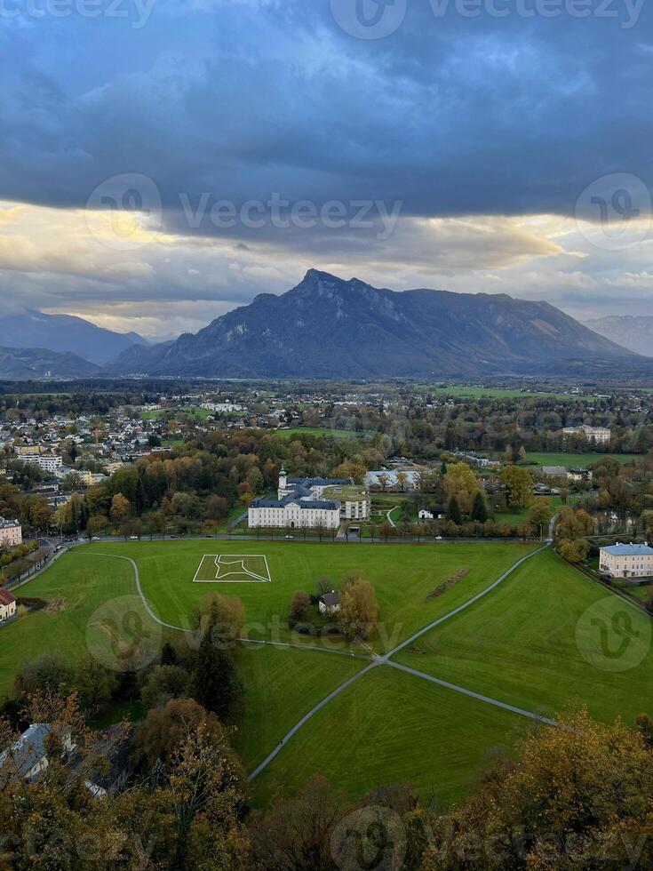 Panoramic view of Salzburg with mountains at the background in the evening at sunset photo