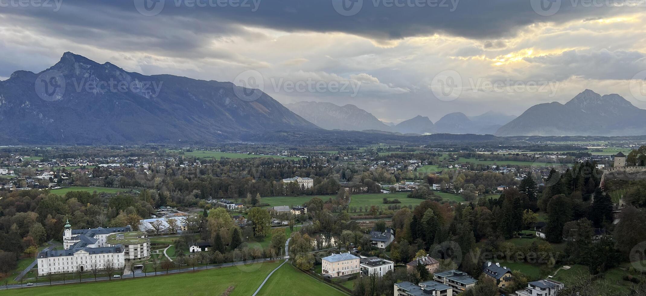 Panoramic view of Salzburg with mountains at the background in the evening at sunset. Banner background format photo