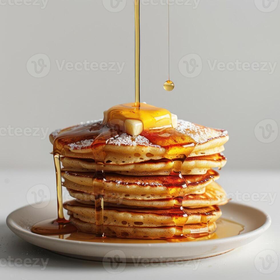 a stack of pancakes with syrup being poured on top photo