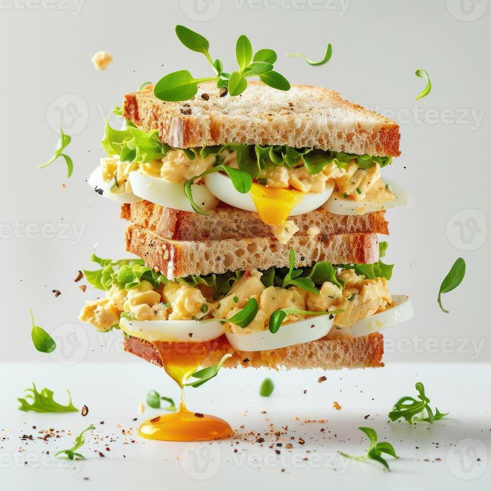 a sandwich with eggs, lettuce, and other toppings photo