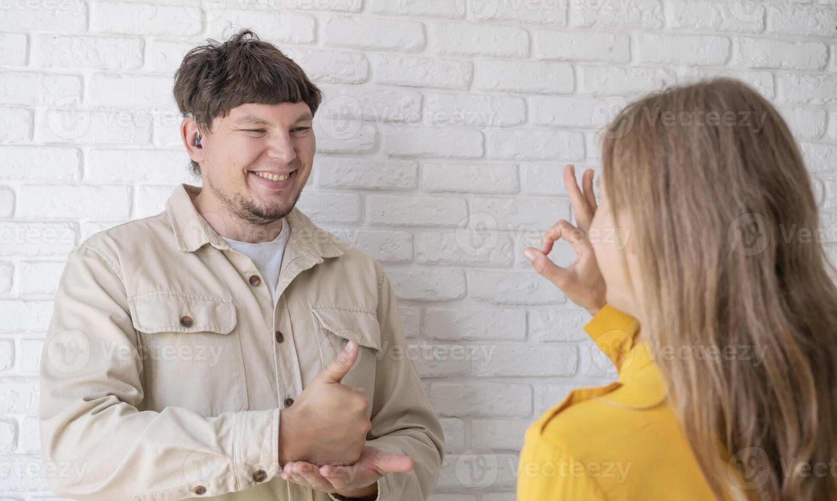 young woman and deaf man with audiology implant, service or help for sound waves photo