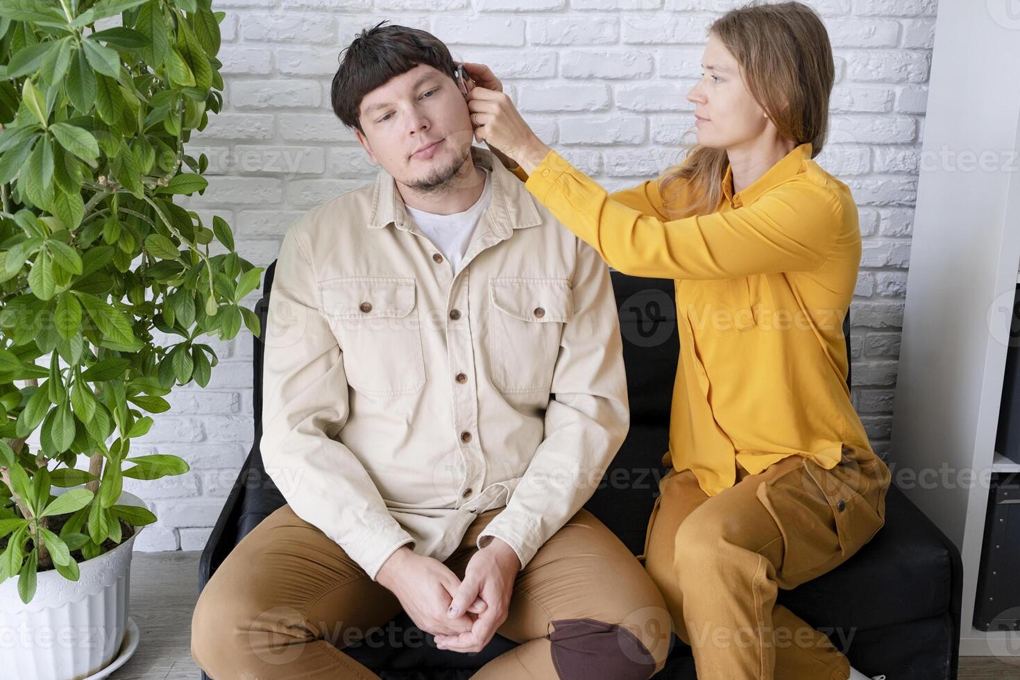 young woman and deaf man with audiology implant, service or help for sound waves photo