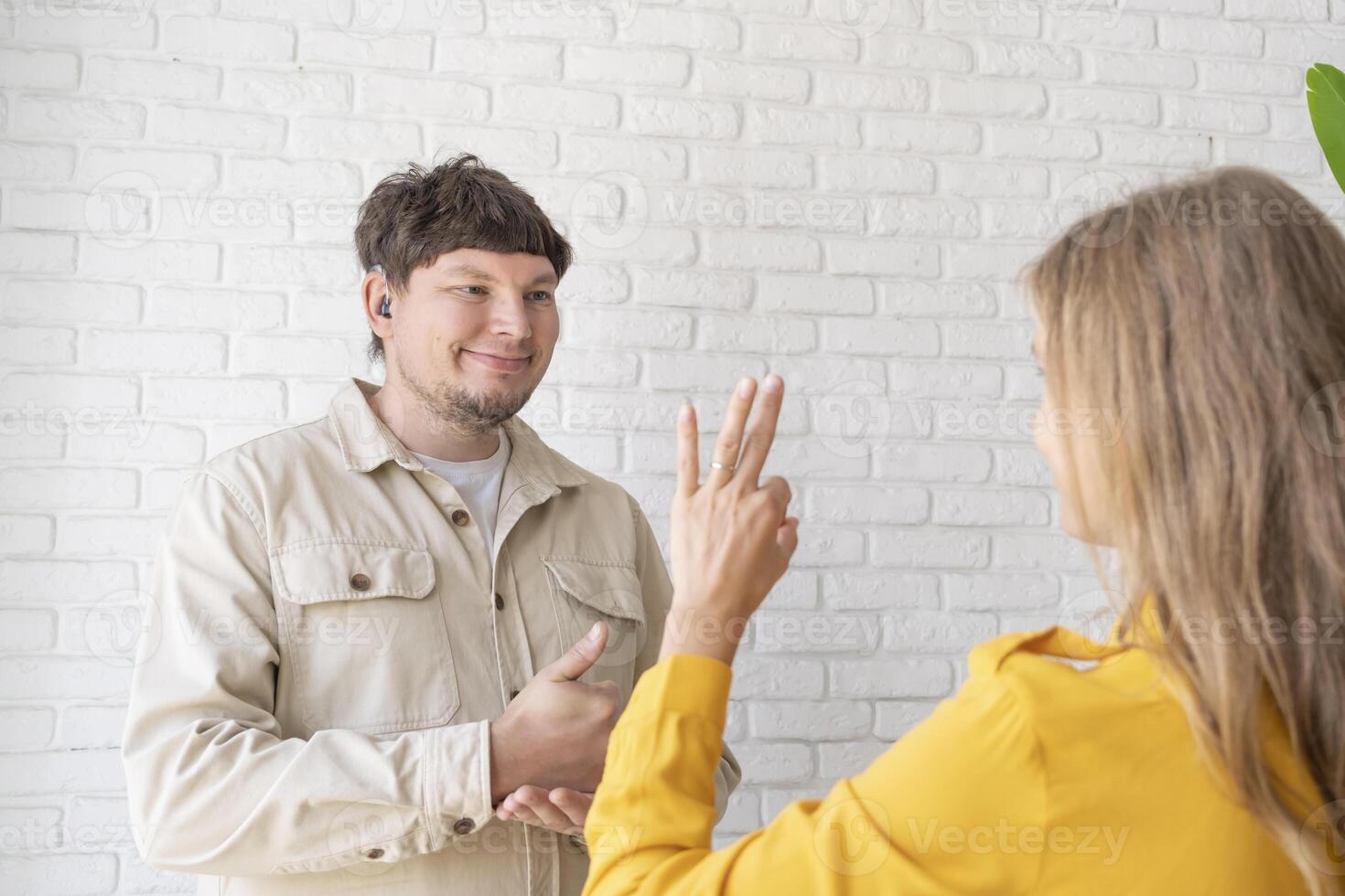 young woman and deaf man with audiology implant, service or help for sound waves photo