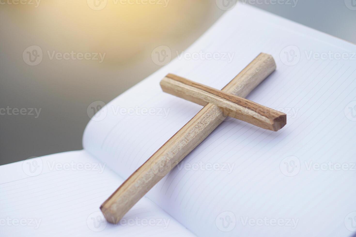 Wooden cross on white paper notebook. Concept, Christian worship. Faith, forgiveness, belief, love, hope, peace and happiness. Crucifix, religious symbol of Christianity. photo