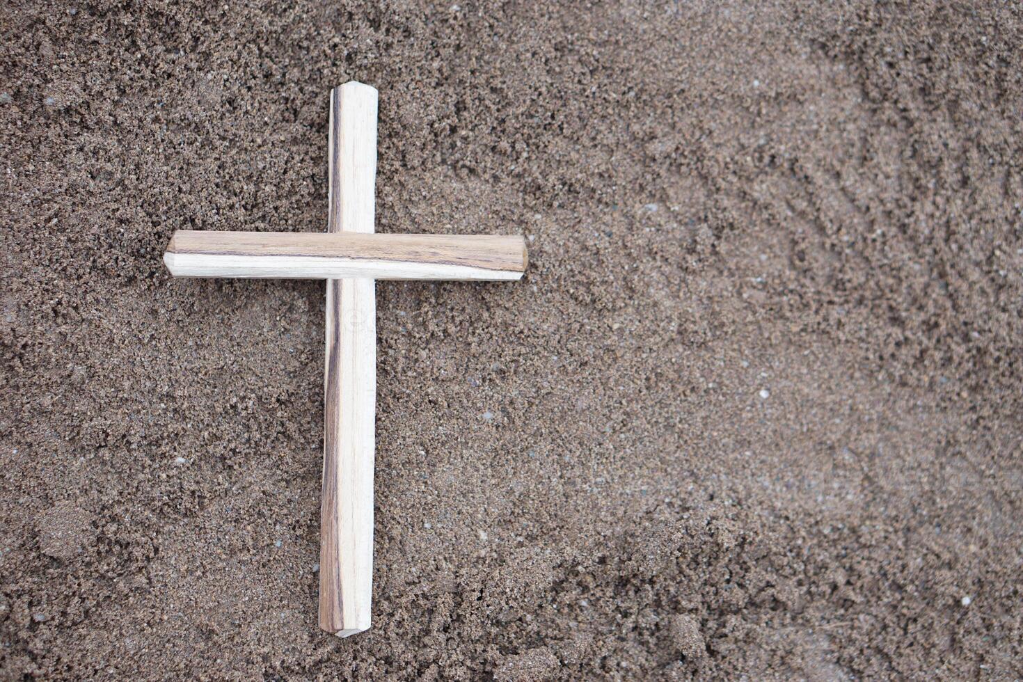 Wooden crucifix on ground. Concept, Christian worship. Faith, forgiveness, belief, love, hope, peace and happiness. Crucifix, religious symbol of Christianity. photo