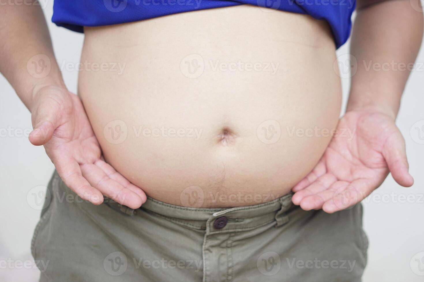 Close up man show his big, thick fat belly. Concept, fat, overweight, health problem of obesity, overweight in men can cause to diseases. photo