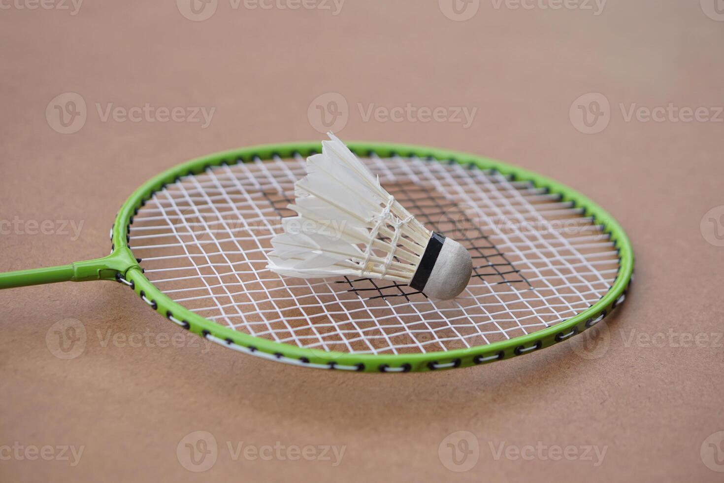 Shuttlecock and racket. Badminton sport equipments on brown background. Concept, sport, exercise, recreation activity for good health. Popular sport for all genders photo