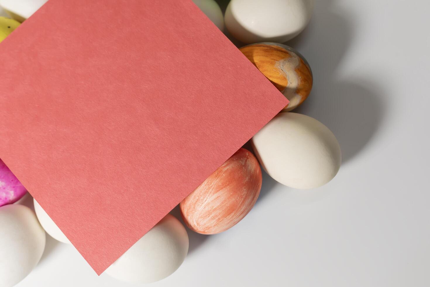 Colorful easter eggs with red blank card on white background photo