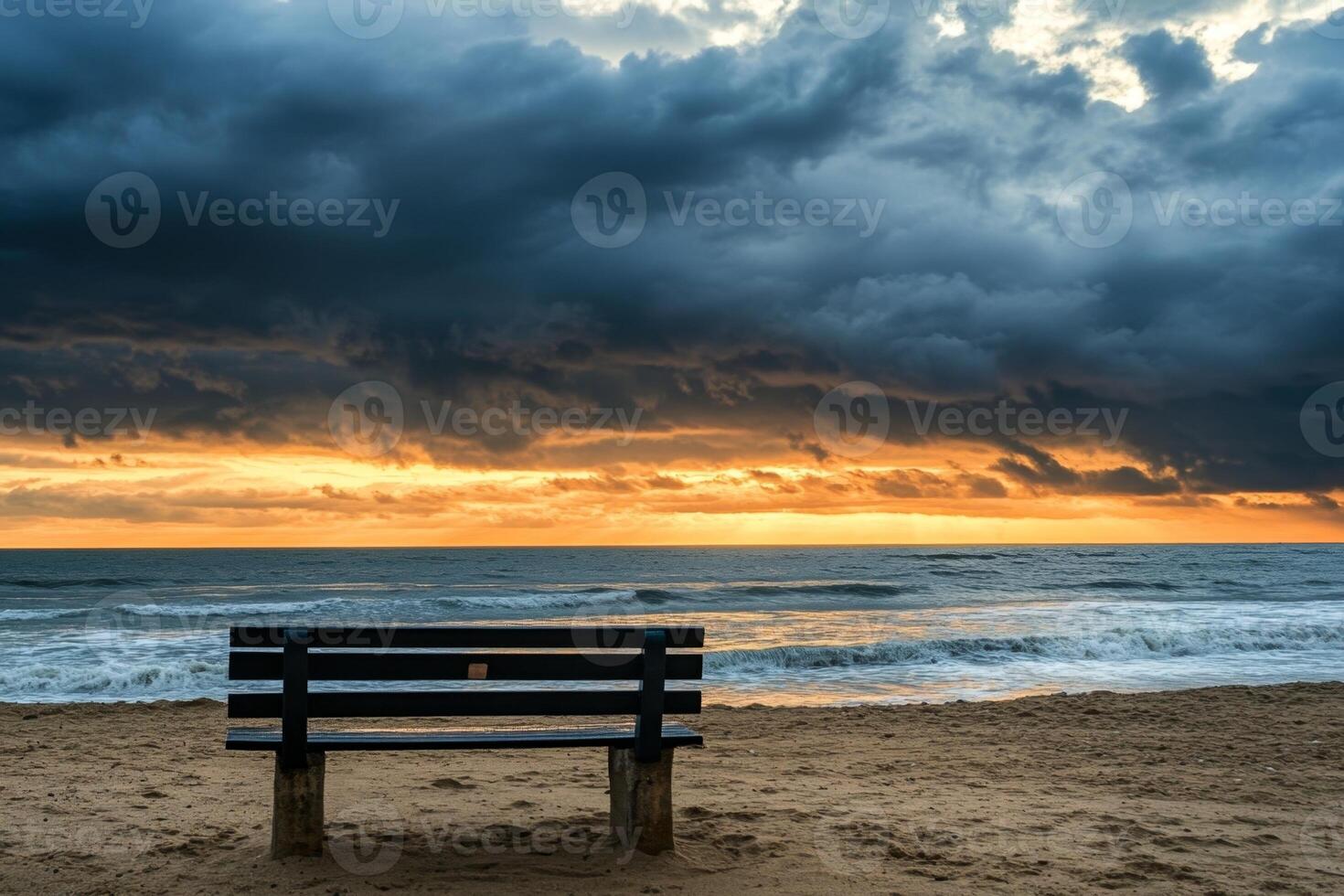 Empty bench standing on a beach with stormy sunrise over the sea photo