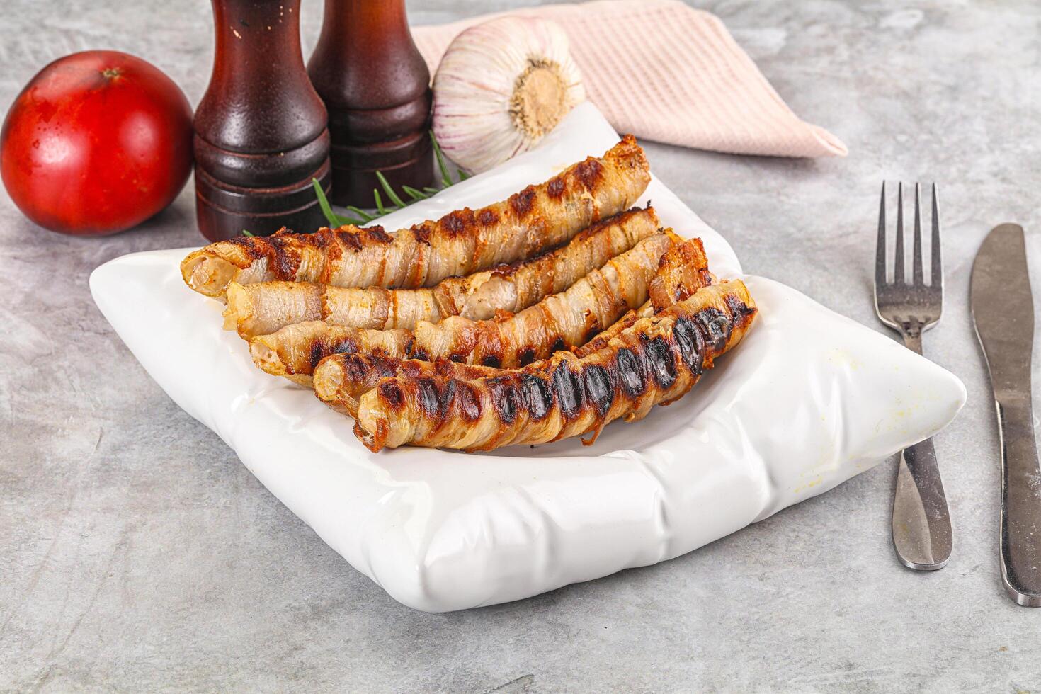 Grilled meat sausages wrapped bacon photo