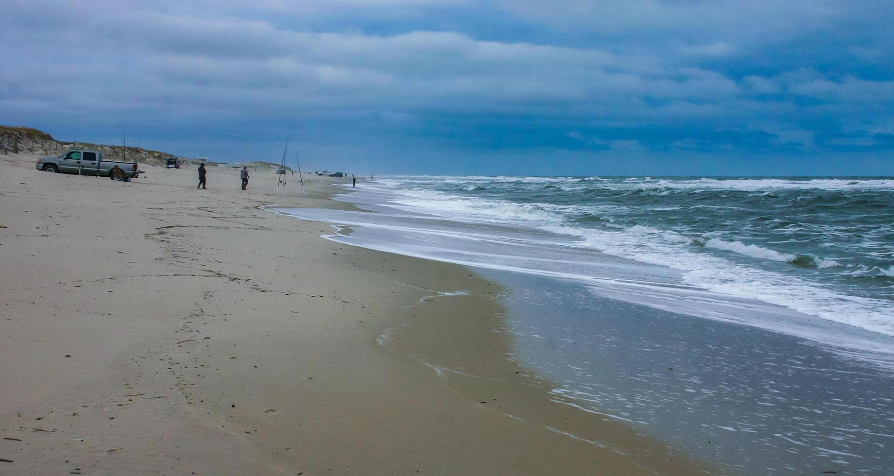 Fishermen on the sandy shore of the Atlantic Ocean in New Jersey, USA photo