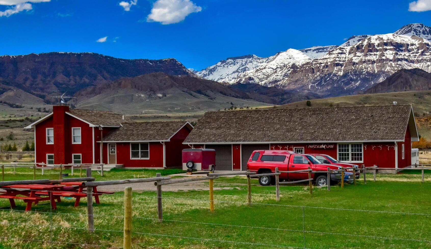 USA, MONTANA - APRIL 28, 2018 Mountain landscape, typical one-story ranch house in a valley among the mountains in Montana photo