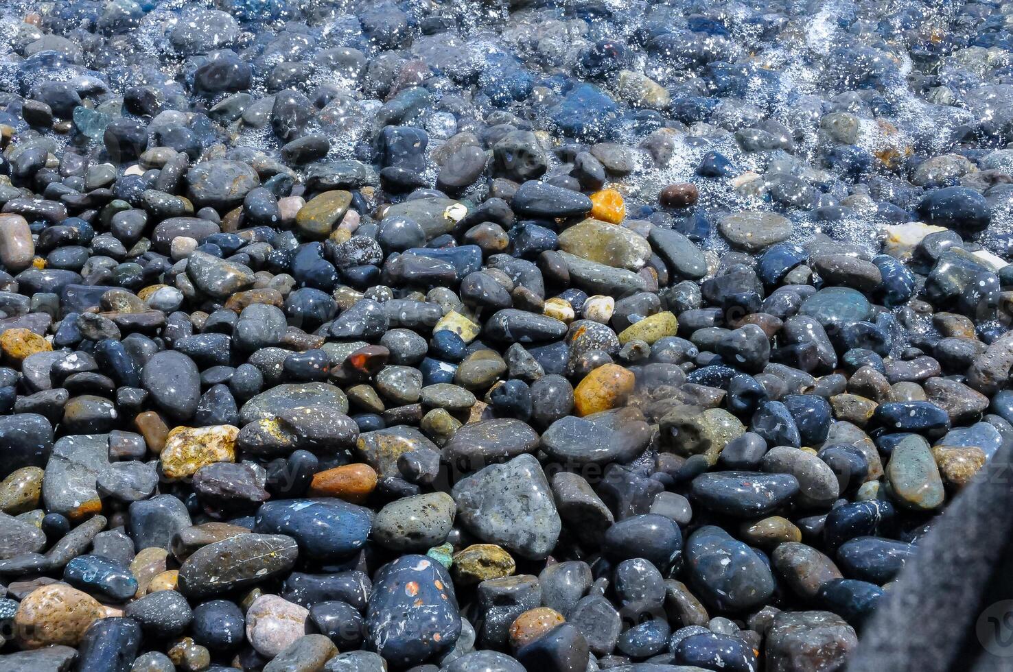 Kara-Dag, a round sea-rolled pebble from a volcanic rock on a pebble beach, Crimea photo