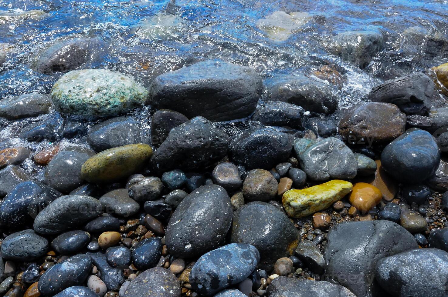 Kara-Dag, a round sea-rolled pebble from a volcanic rock on a pebble beach, Crimea photo