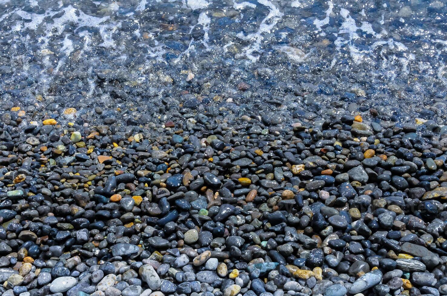 Kara-Dag, a round sea-rolled pebble from a volcanic rock on a pebble beach, Crimea photo