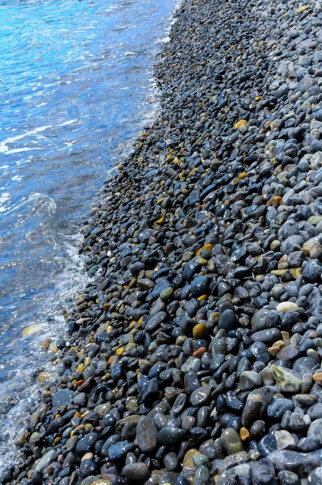 Kara-Dag, a round sea-rolled pebble from a volcanic rock on a pebble beach, Crimea photo