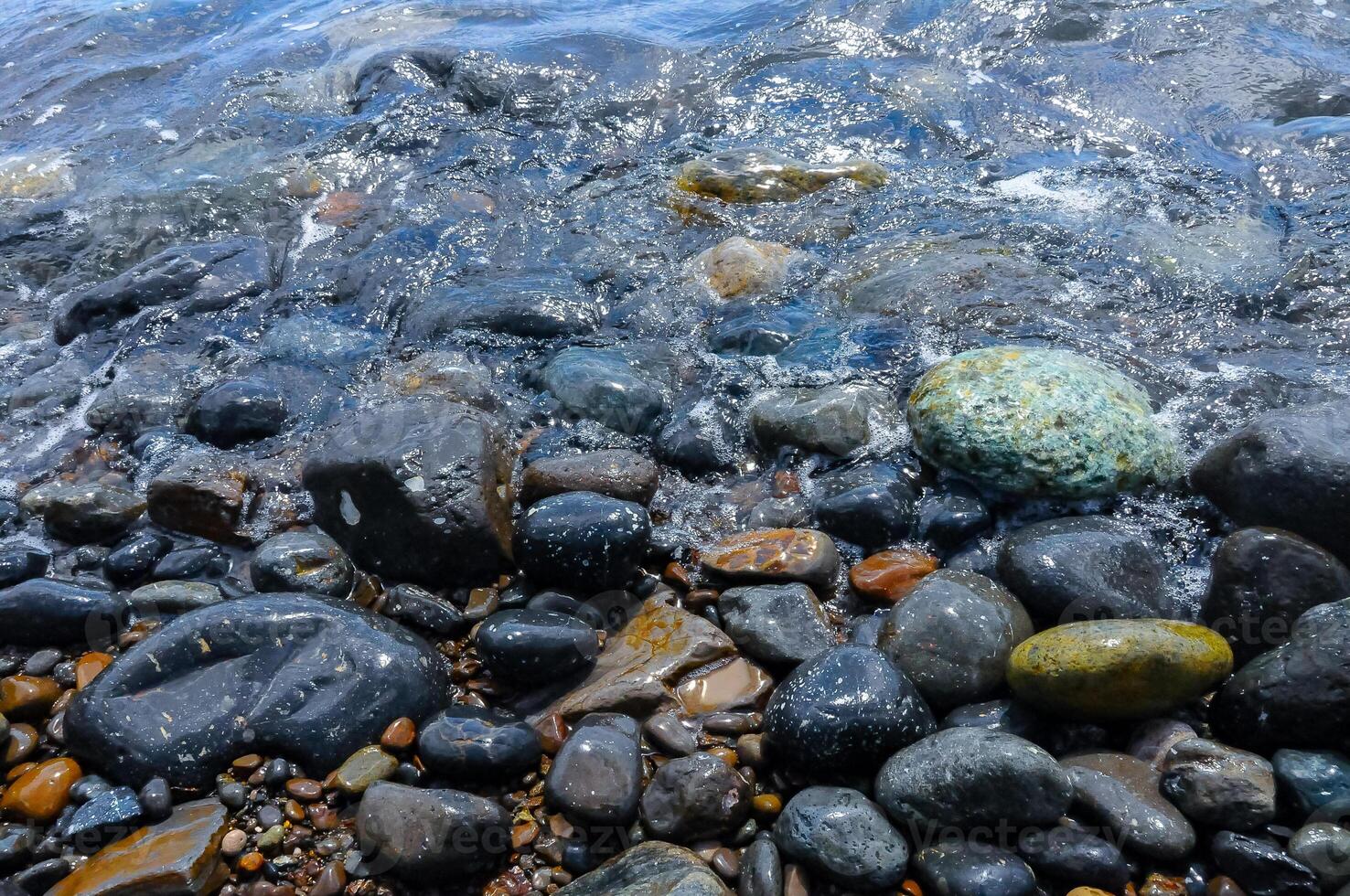 Kara-Dag, a round sea-rolled pebble from a volcanic rock on a pebble beach, Crimea photo