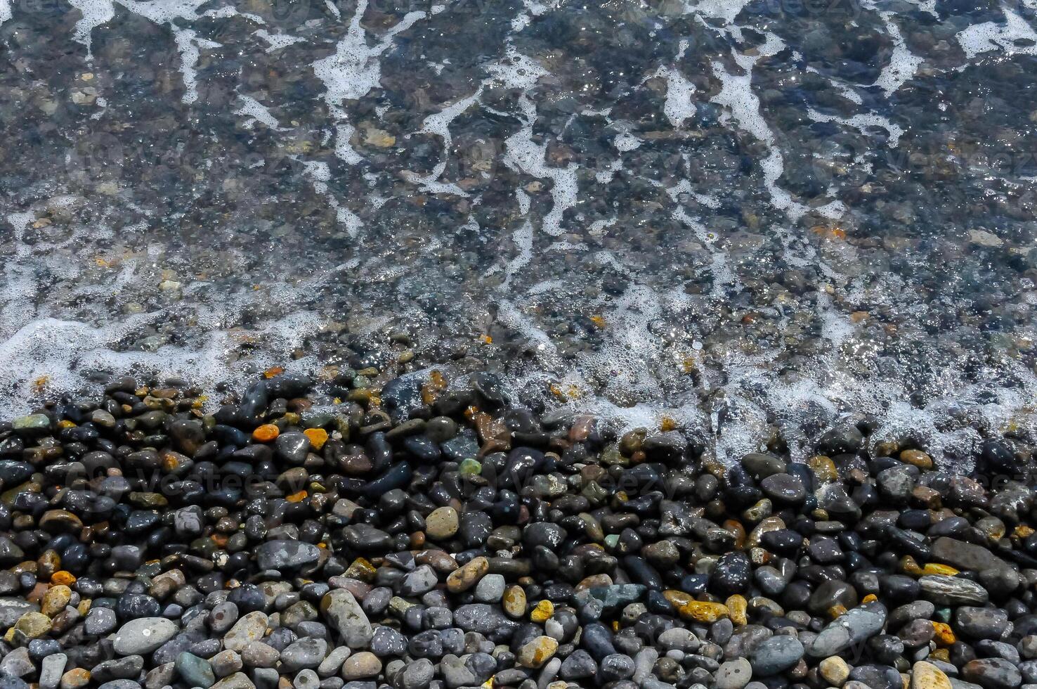 Kara-Dag, a round sea-rolled pebble from a volcanic rock on a pebble beach, Crimea photo