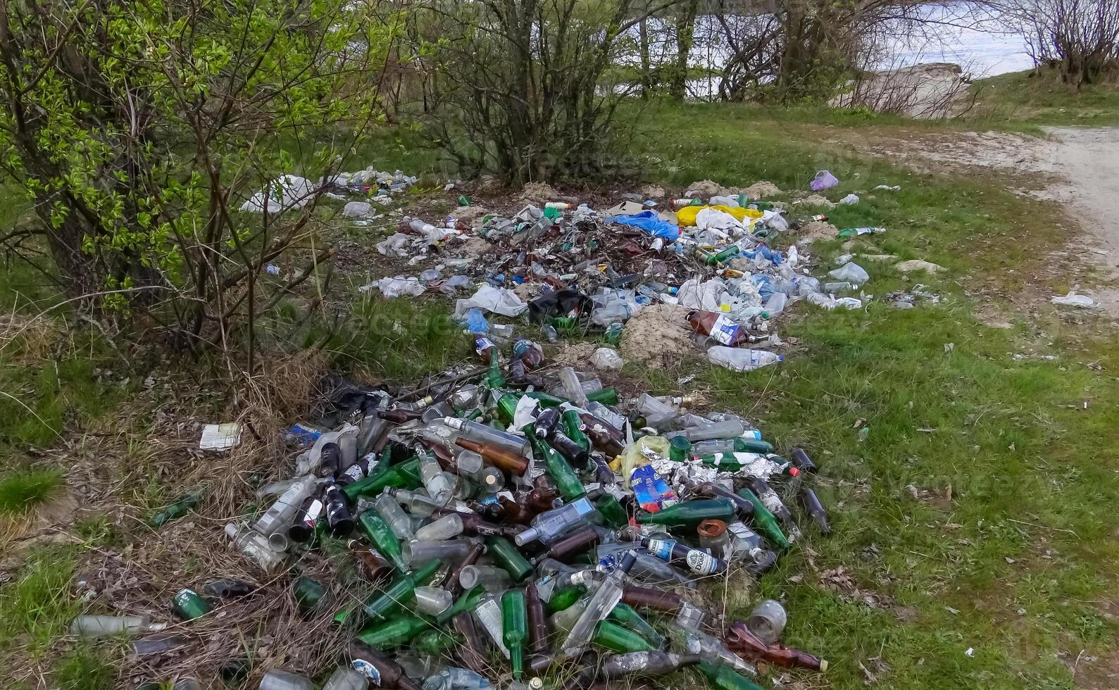 Plastic, polyethylene and glass trash in the wild, environmental pollution photo