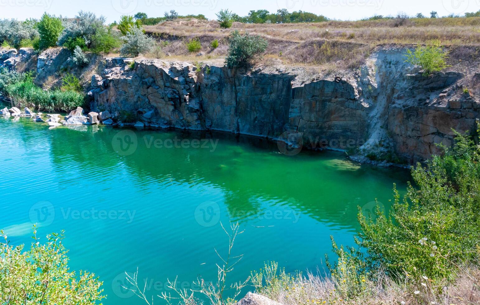 View of the flooded granite quarry with turquoise clear water, Ukraine photo