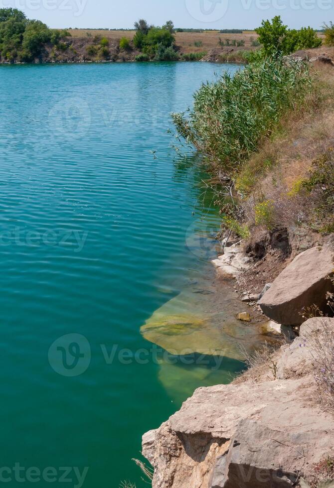 View of the flooded granite quarry with turquoise clear water, Ukraine photo