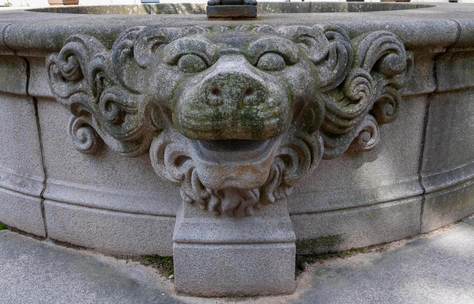 NANTES, FRANCE - SEPTEMBER 12, 2017 - Lion's head on the wall of an old well near an old brick building in the center of Nantes, France photo