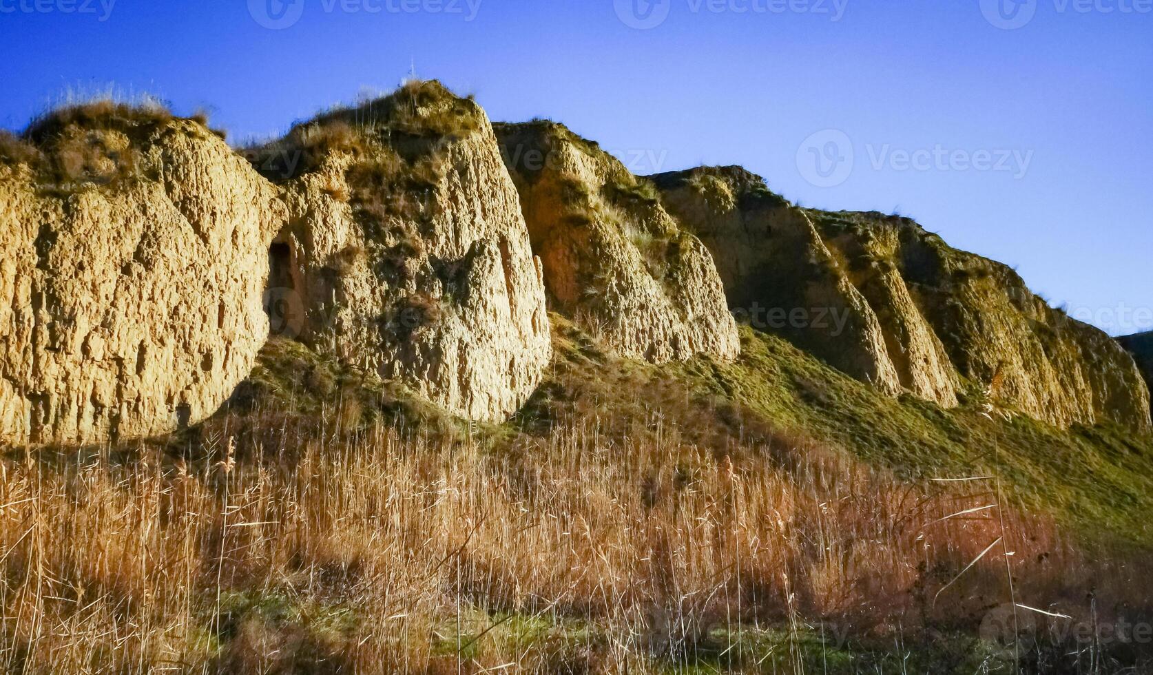 Clay eroded rocks, steep coastal slope around the lake photo