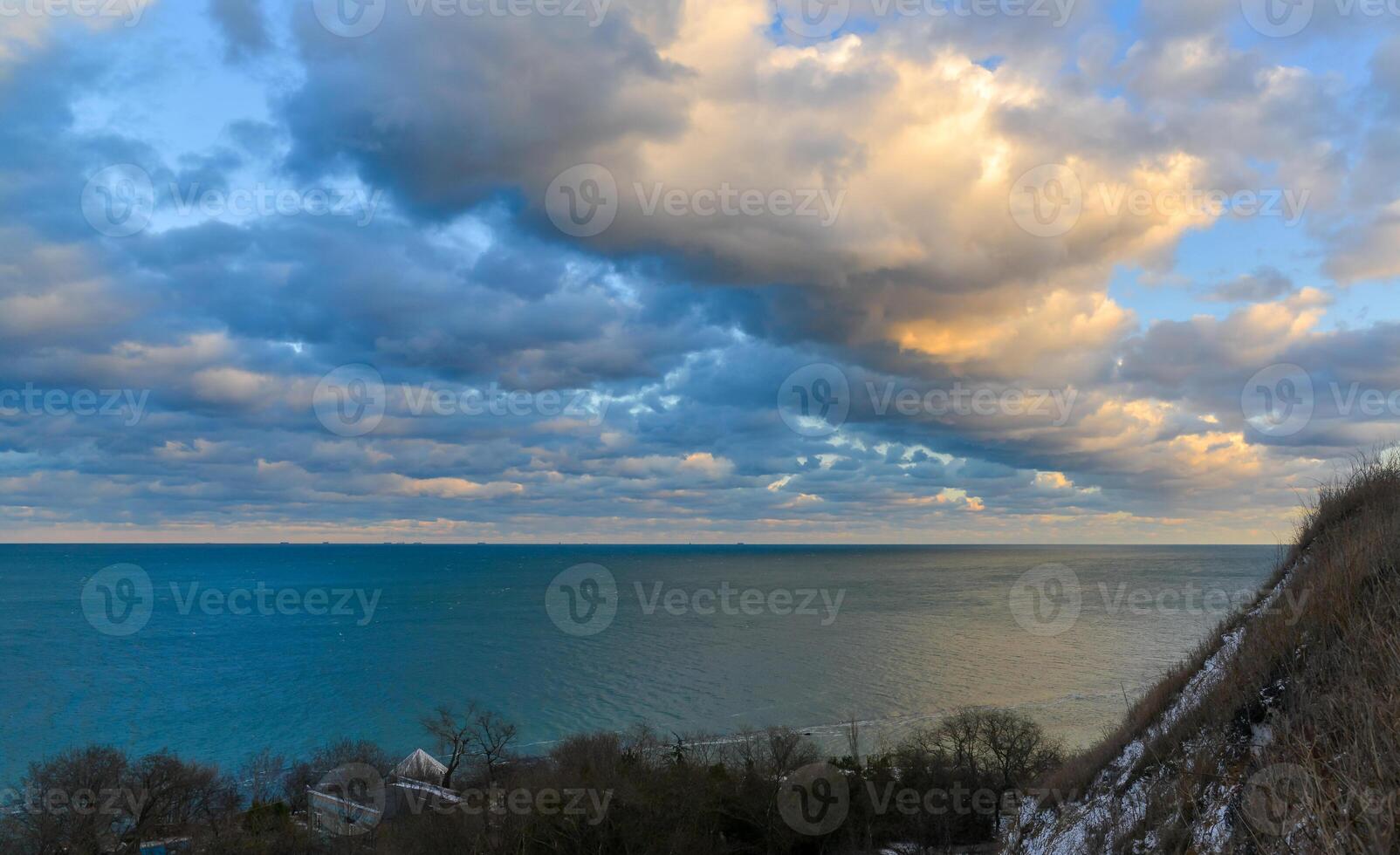 Cumulus white clouds in the evening at sunset low over the Black Sea. photo