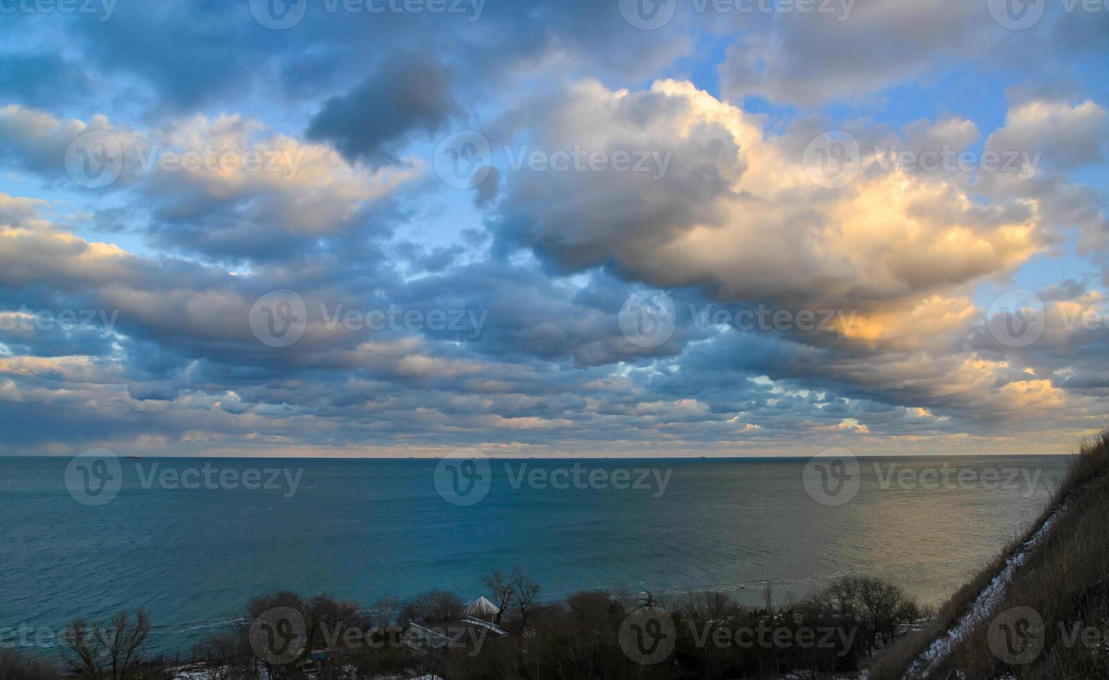 Cumulus white clouds in the evening at sunset low over the Black Sea. photo